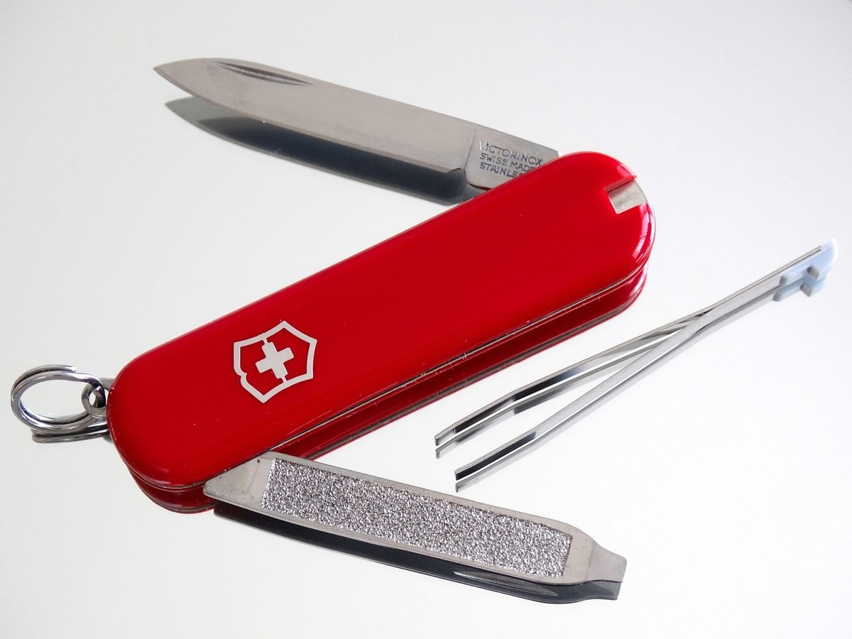 Couteau suisse rouge déplié montrant lame, lime et autres outils