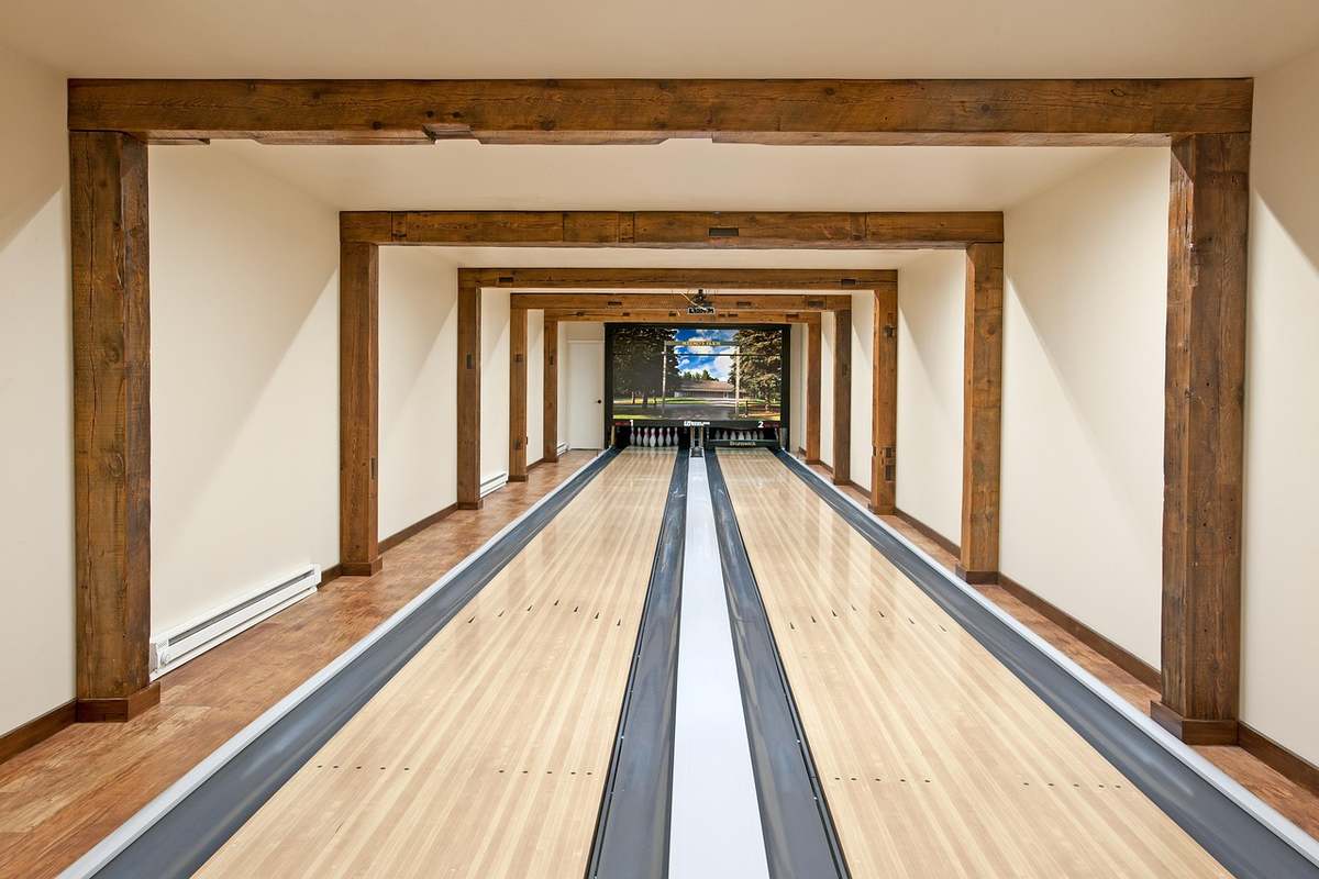 Allée de bowling intérieure avec pistes en bois et poutres apparentes Allée de bowling intérieure avec pistes en bois et poutres apparentes