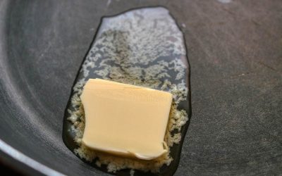 Un morceau de beurre qui fond doucement dans une poêle chaude