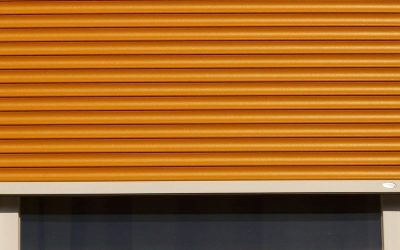 fenêtre avec volet roulant orange partiellement abaissé cadre blanc vitre sombre
