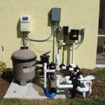 Pompe, filtre, tuyaux et commande pour nettoyer une piscine extérieure